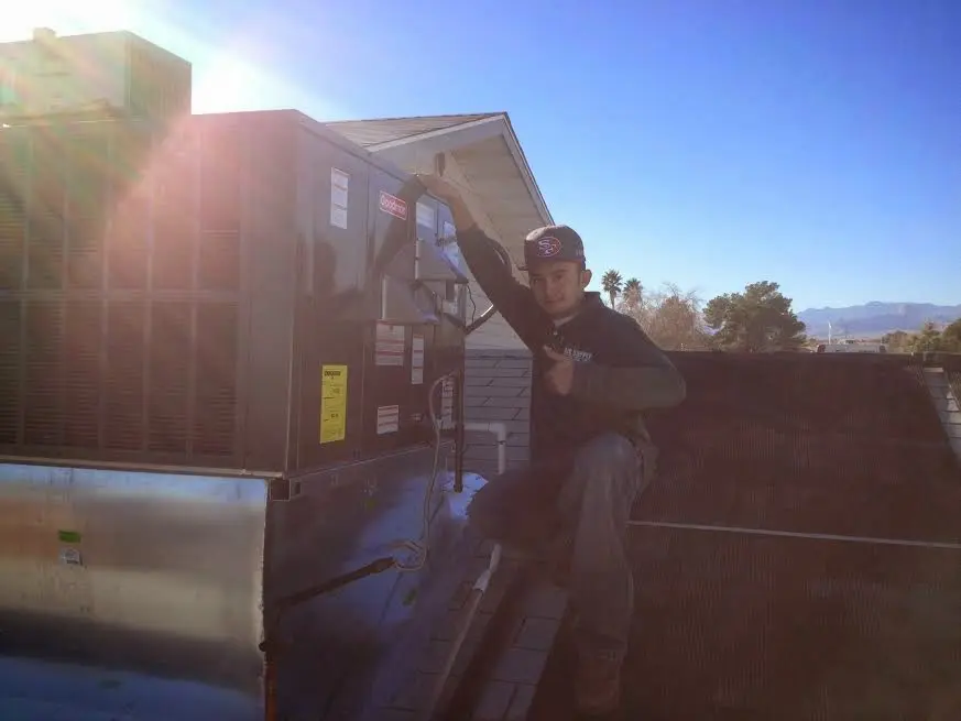 HVAC technician performing Boiler Repair on a rooftop unit in Philipstown